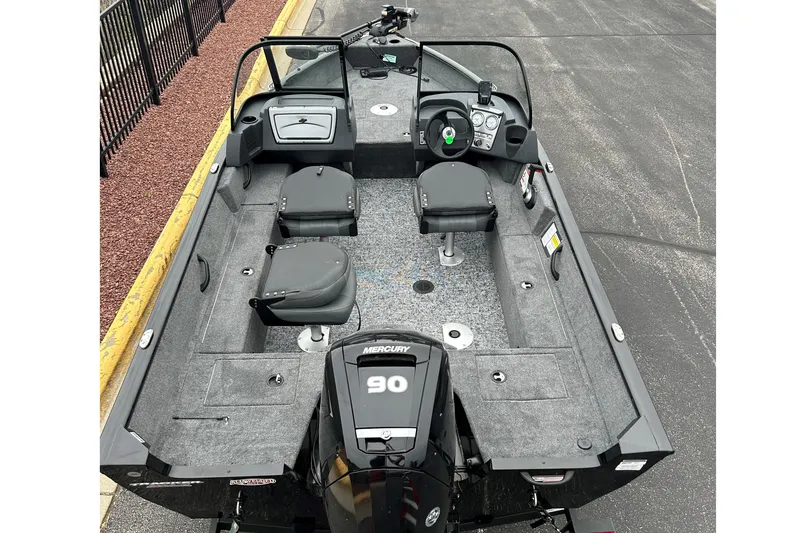 Slide: The Image of 2026 Tracker Super Guide V-16 SC boat interior with Mercury 90 engine, gray seating, and steering console. - 2