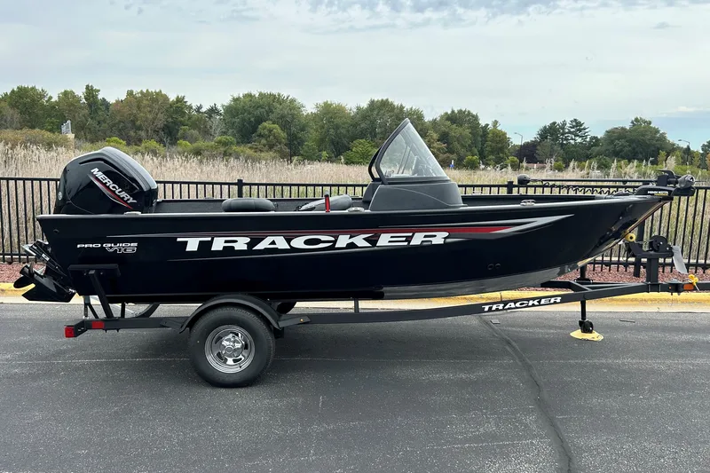 The Image of 2026 Tracker Super Guide V-16 SC boat on trailer, parked outdoors. - 0