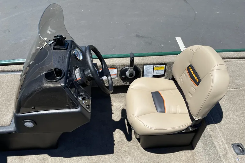 Slide: The Image of 2026 Tracker Bass Tracker Classic Limited boat interior with steering wheel and beige seat. - 5