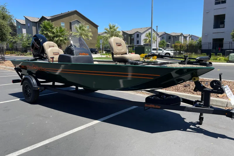 Slide: The Image of 2026 Tracker Bass Tracker Classic Limited boat on trailer in sunny parking lot. - 2