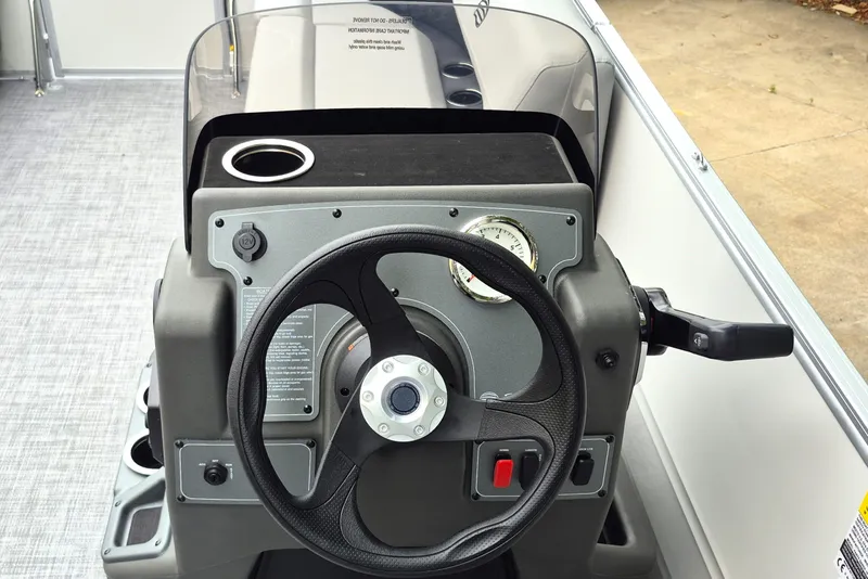 Slide: The Image of Steering console of 2026 Sun Tracker Party Barge 16 DLX with cup holder and controls. - 8