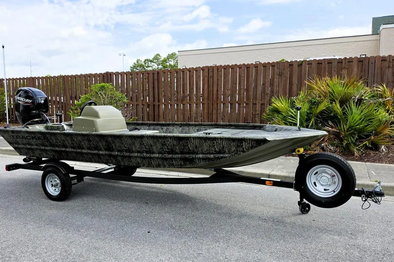 Slide: The Image of 2026 Tracker Grizzly 1648 SC boat on trailer, parked outdoors, featuring Mercury outboard motor. - 3