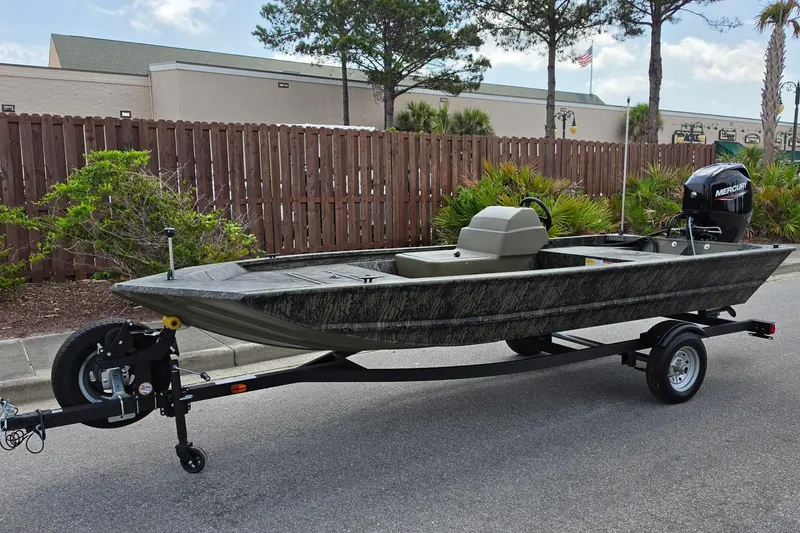 Slide: The Image of 2026 Tracker Grizzly 1648 SC boat on trailer, parked outdoors. - 8