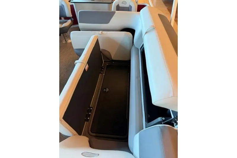 Slide: The Image of 2026 Sun Tracker Fishin' Barge 22 DLX boat seat storage compartment open. - 6