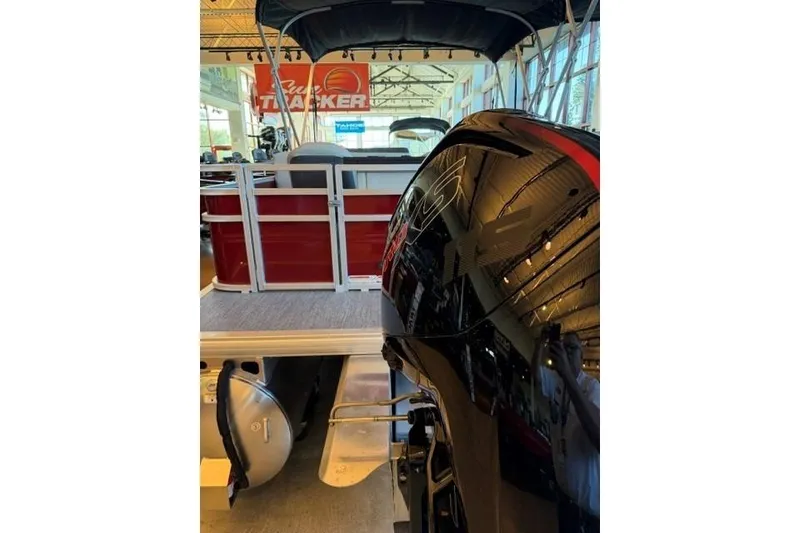 Slide: The Image of 2026 Sun Tracker Fishin' Barge 22 DLX pontoon boat displayed indoors. - 3