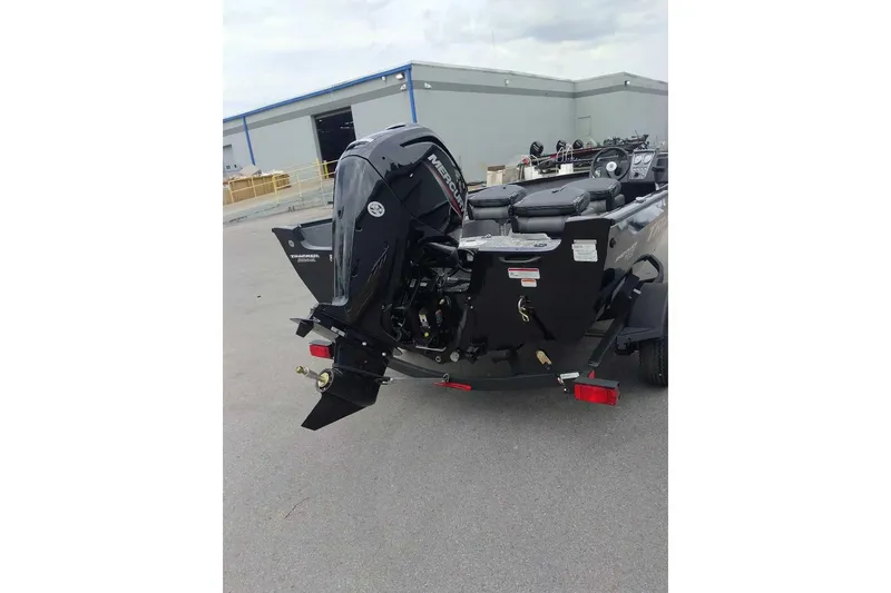 Slide: The Image of 2026 Tracker Pro Guide V-16 SC boat with Mercury outboard motor in a parking lot. - 3