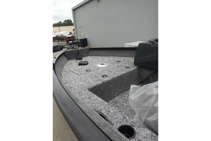 Slide: The Image of 2026 Tracker Pro Guide V-16 SC boat interior with carpeted deck and storage compartments. - 4