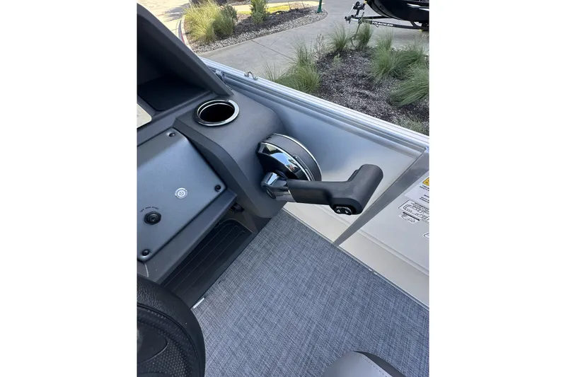 Slide: The Image of 2026 Sun Tracker Party Barge 16 DLX control panel with throttle lever and cup holder. - 20