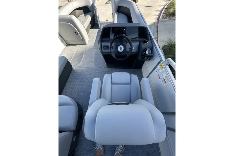 Slide: The Image of Interior view of 2026 Sun Tracker Party Barge 16 DLX with modern seating and steering console. - 22