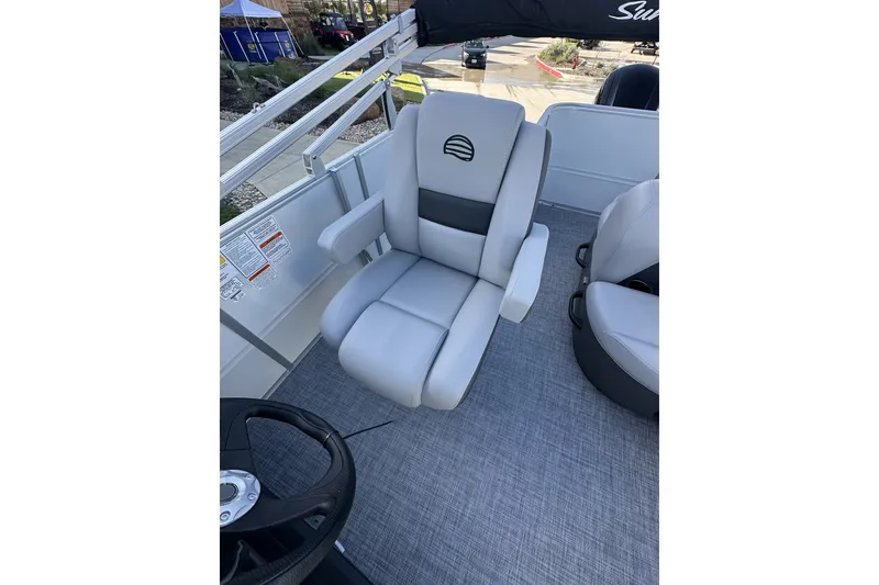 Slide: The Image of 2026 Sun Tracker Party Barge 16 DLX boat seat, featuring plush gray upholstery and armrests. - 19