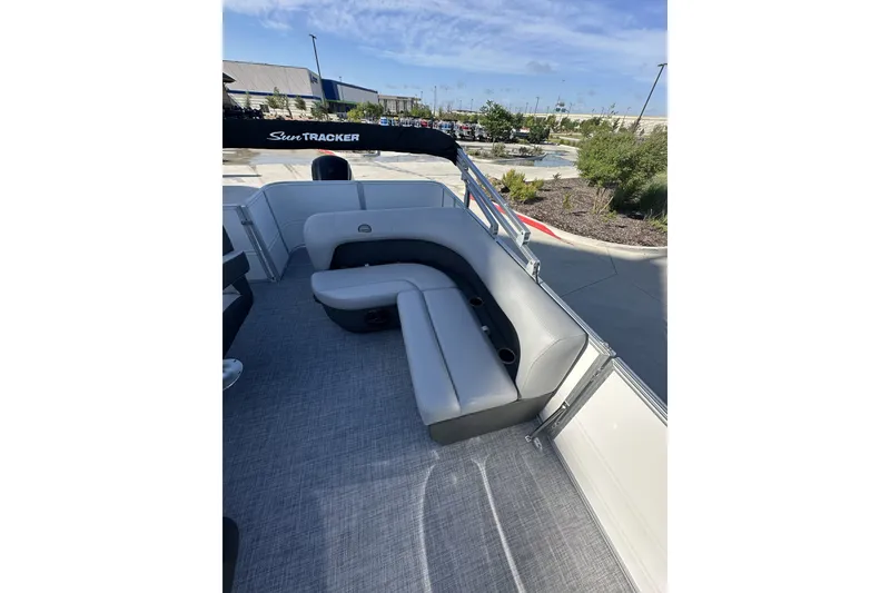 Slide: The Image of 2026 Sun Tracker Party Barge 16 DLX interior with gray seating and cup holders. - 14
