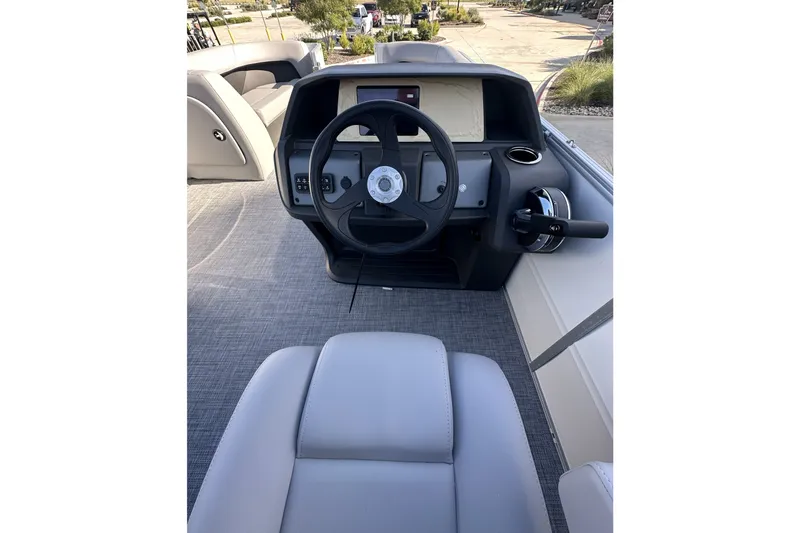 Slide: The Image of 2026 Sun Tracker Party Barge 16 DLX helm with steering wheel and controls. - 17