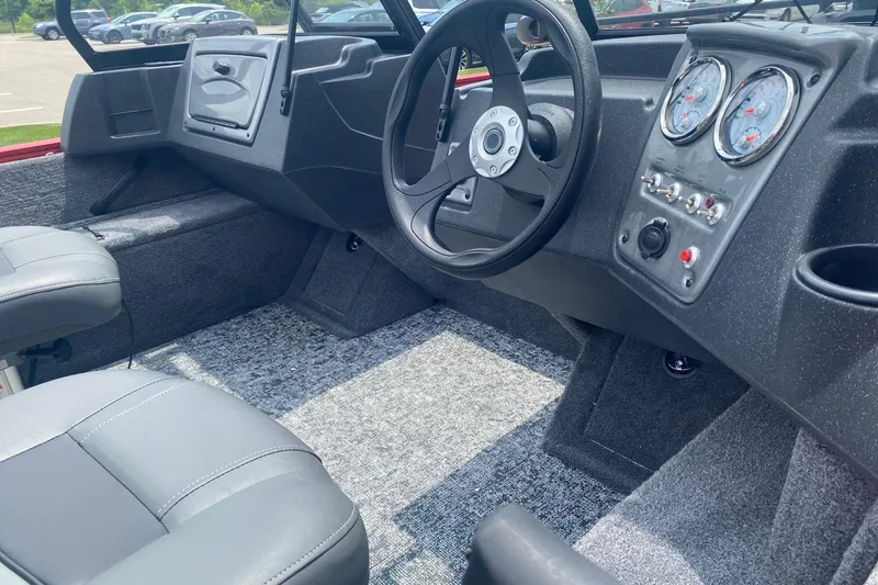 Slide: The Image of Interior of 2026 Tracker Pro Guide V-16 WT boat with steering wheel and dashboard controls. - 51