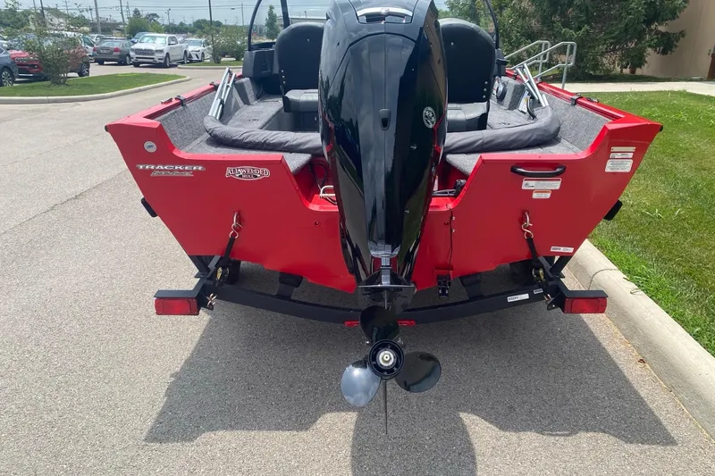 Slide: The Image of 2026 Tracker Pro Guide V-16 WT boat, red exterior, parked on a trailer. - 5