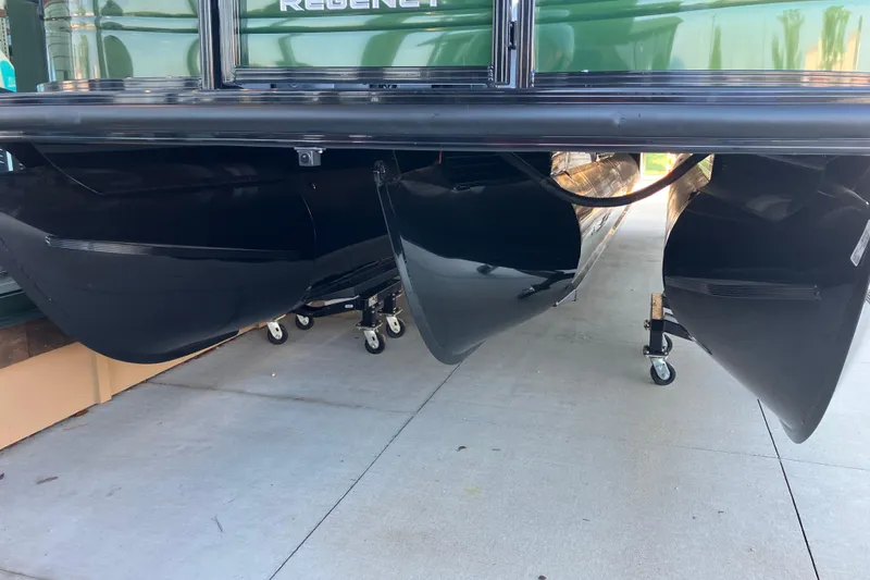 Slide: The Image of 2026 Regency 230 DL pontoon boat underside with black pontoons on display. - 4