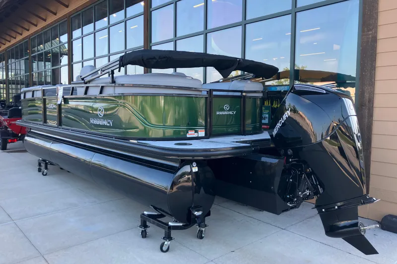 Slide: The Image of 2026 Regency 230 DL pontoon boat with Mercury outboard motor, displayed outdoors. - 17