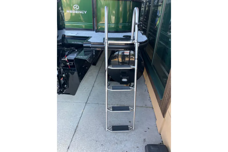 Slide: The Image of Stainless steel ladder on a 2026 Regency 230 DL boat, docked outdoors. - 16