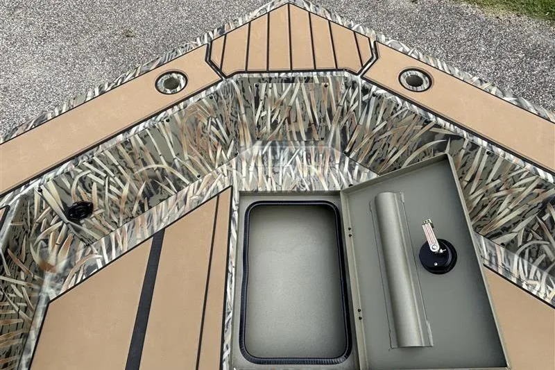 Slide: The Image of 2026 Tracker Grizzly 1756 T Marsh boat interior with camo design and storage compartment. - 7