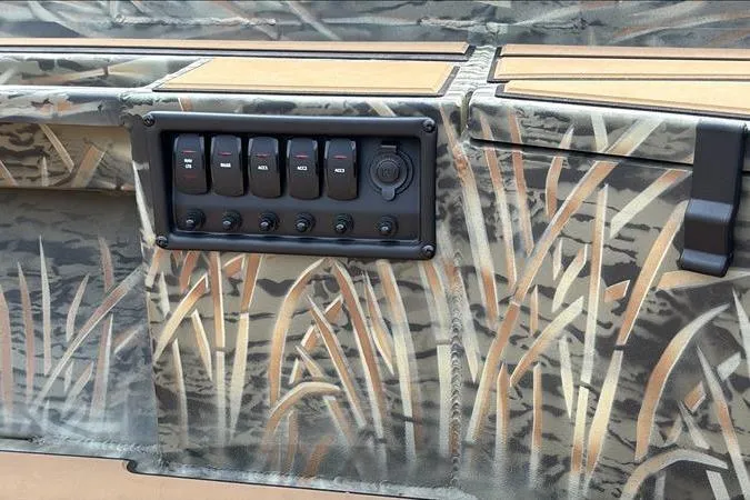Slide: The Image of 2026 Tracker Grizzly 1756 T Marsh boat with camo design and control panel. - 13