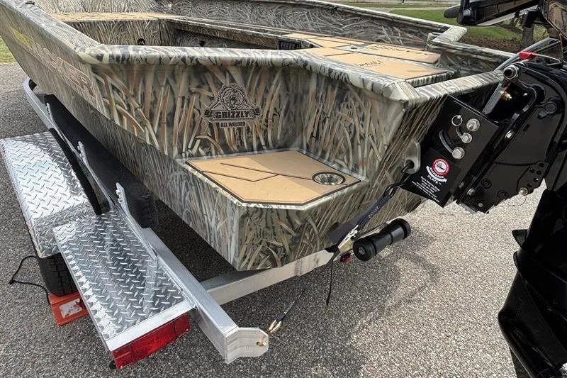 Slide: The Image of 2026 Tracker Grizzly 1756 T Marsh boat on trailer, camo design, rear view. - 4