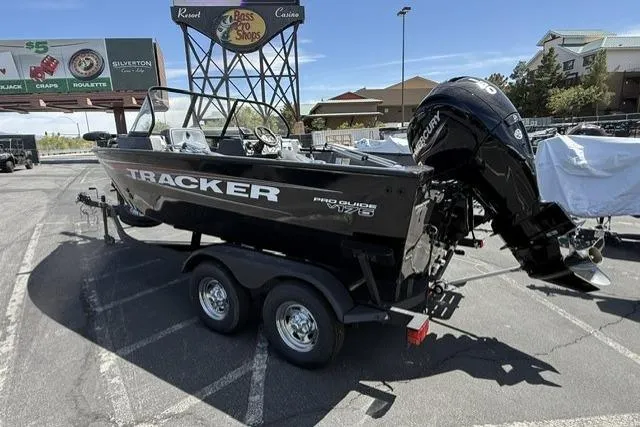 Slide: The Image of 2025 Tracker Pro Guide V-175 WT boat on trailer in parking lot. - 2