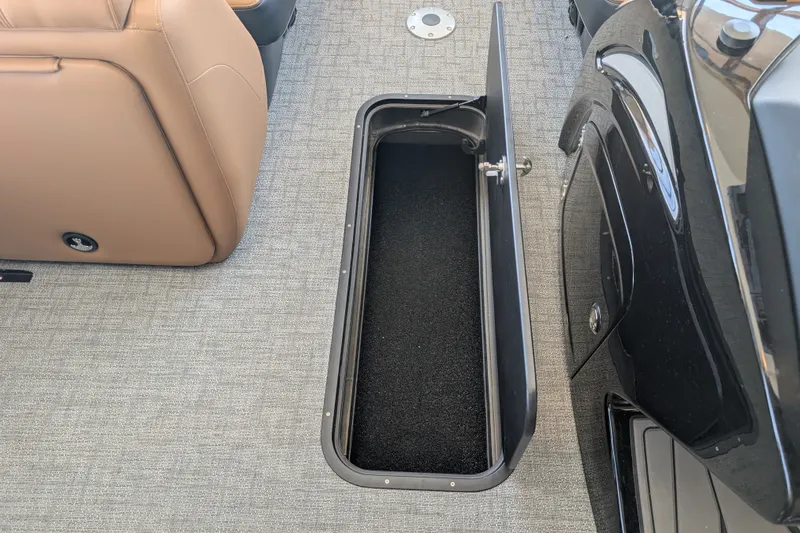 Slide: The Image of Open storage compartment on 2026 Regency 230 DL boat with beige seating and gray flooring. - 14