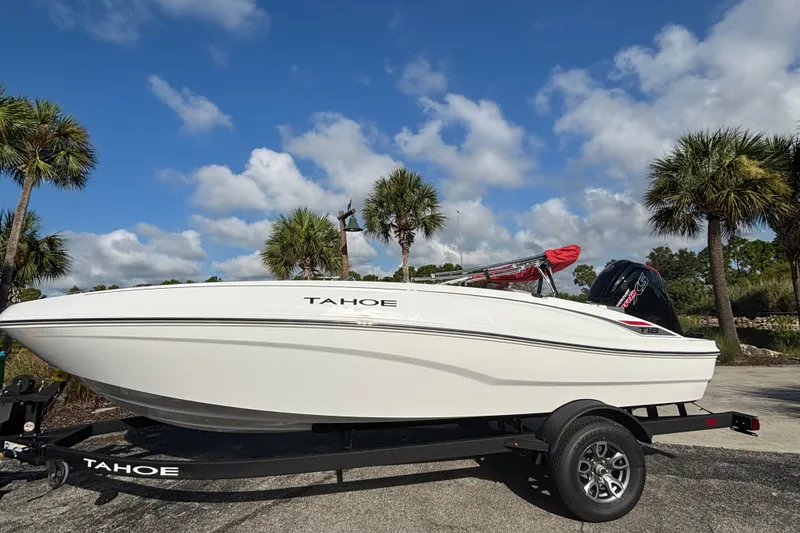 Slide: The Image of 2026 Tahoe T18 boat on trailer, parked outdoors with palm trees and blue sky. - 1