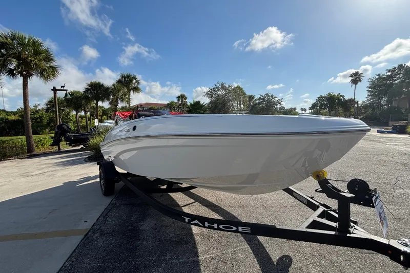 Slide: The Image of 2026 Tahoe T18 boat on trailer under clear blue sky. - 7