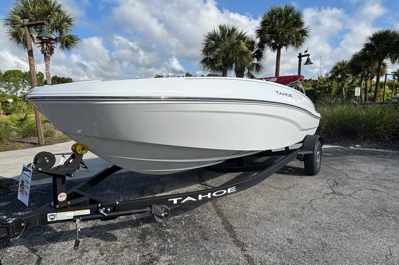 The Image of 2026 Tahoe T18 boat on trailer, parked outdoors with palm trees in background. - 0