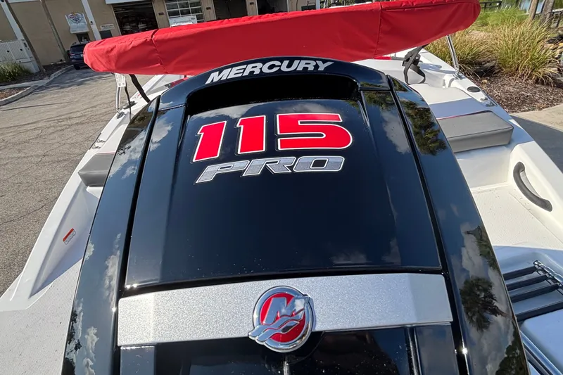 Slide: The Image of 2026 Tahoe T18 boat with Mercury 115 Pro engine, red canopy, parked outdoors. - 4