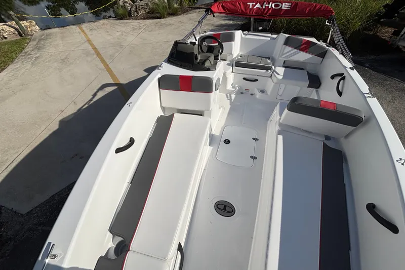 Slide: The Image of 2026 Tahoe T18 boat interior with seating and steering wheel, docked near a ramp. - 13