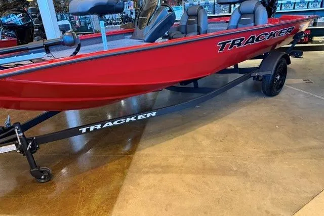 Slide: The Image of Red 2026 Tracker Pro Team 175 boat on display with trailer indoors. - 2