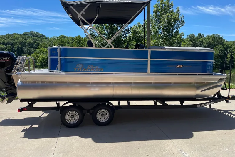 The Image of 2026 Sun Tracker Party Barge 20 DLX pontoon boat on trailer, parked outdoors. - 0