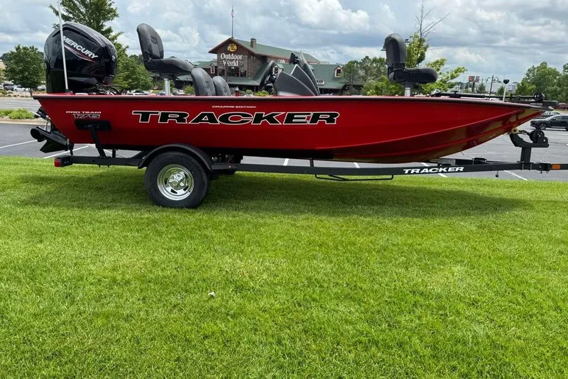 Slide: The Image of 2026 Tracker Pro Team 175 Crappie Edition boat on trailer, parked on grass. - 2