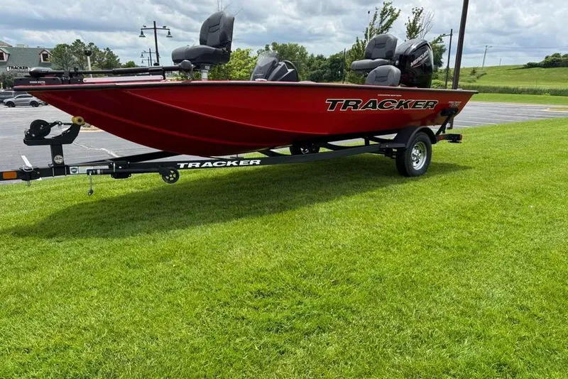 Slide: The Image of 2026 Tracker Pro Team 175 Crappie Edition boat on grassy area, red hull, trailer attached. - 3
