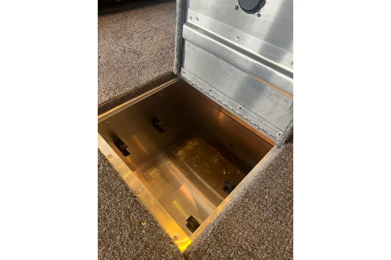 Slide: The Image of Open storage compartment in 2026 Tracker Pro 170 boat, featuring carpeted flooring. - 13