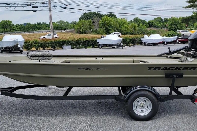 The Image of 2026 Tracker Grizzly 1654 T Sportsman boat on trailer in outdoor setting. - 0