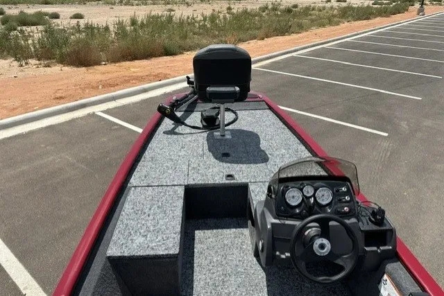 Slide: The Image of 2026 Tracker Pro 170 boat interior with steering wheel and seating in a parking lot. - 13