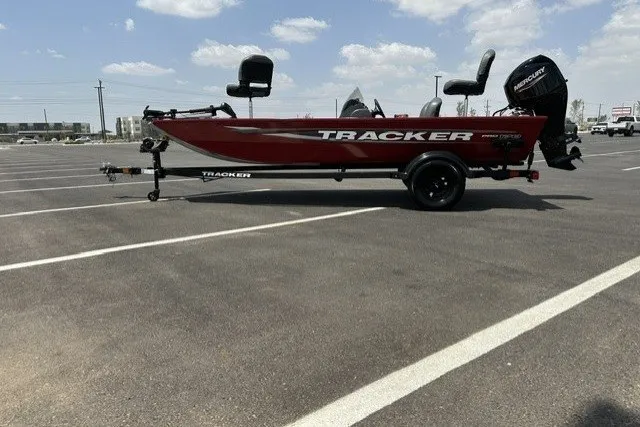 The Image of 2026 Tracker Pro 170 boat in parking lot, side view, red color, clear sky background. - 0