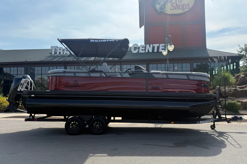 Slide: The Image of 2026 Regency 230 DL pontoon boat on trailer outside a shopping center. - 4