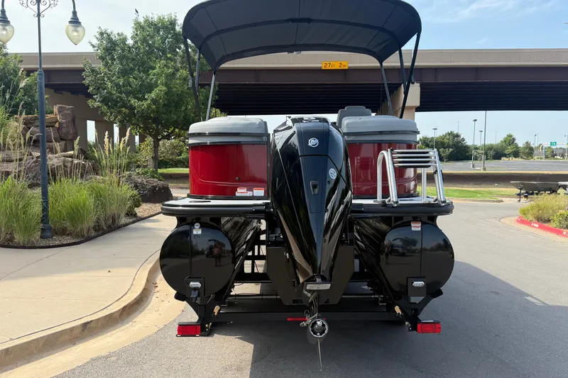 Slide: The Image of 2026 Regency 230 DL pontoon boat with outboard motor, parked under a bridge. - 6