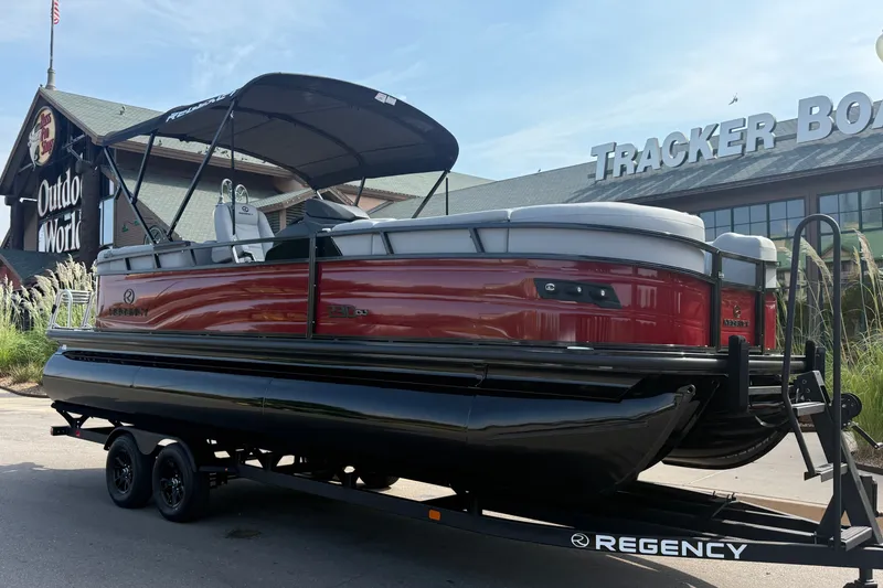 Slide: The Image of 2026 Regency 230 DL pontoon boat on trailer outside Tracker Boats store. - 7