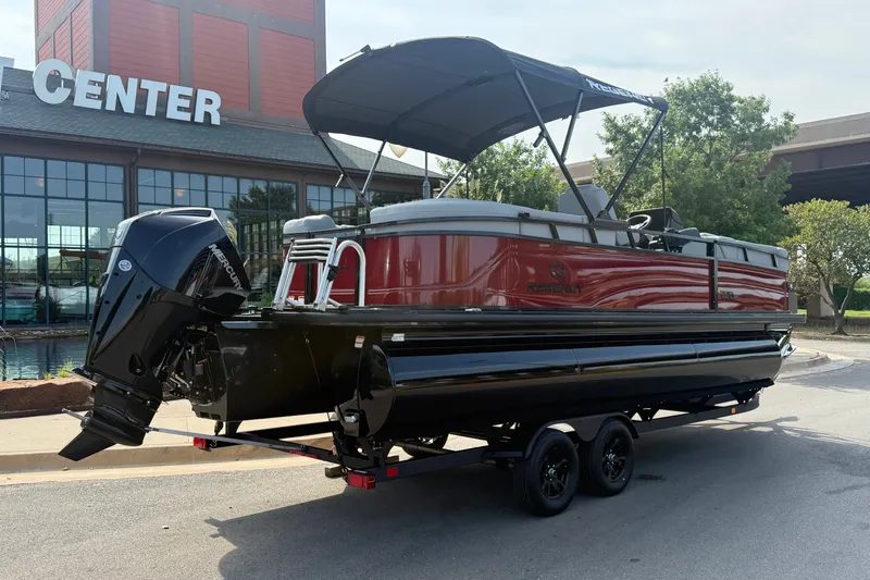 Slide: The Image of 2026 Regency 230 DL pontoon boat on trailer, parked outside a center. - 5