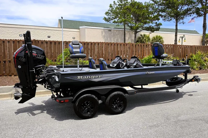 Slide: The Image of 2026 Ranger RT188P fishing boat on trailer, parked outdoors, featuring sleek design and modern equipment. - 2