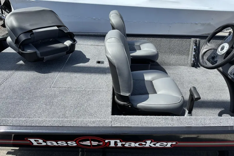 Slide: The Image of 2026 Tracker Bass Tracker Classic XL boat interior with gray seating and steering wheel. - 2