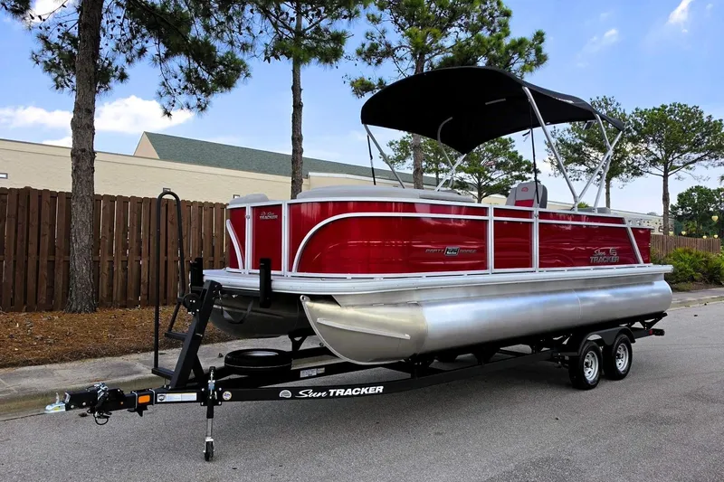 Slide: The Image of 2026 Sun Tracker Party Barge 22 RF DLX pontoon boat on trailer, parked outdoors. - 11