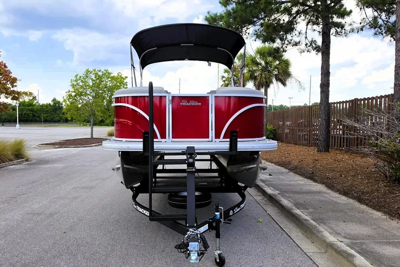 Slide: The Image of 2026 Sun Tracker Party Barge 22 RF DLX pontoon boat on trailer, parked outdoors. - 7