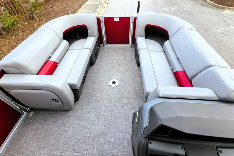 Slide: The Image of 2026 Sun Tracker Party Barge 22 RF DLX interior with gray and red seating. - 16