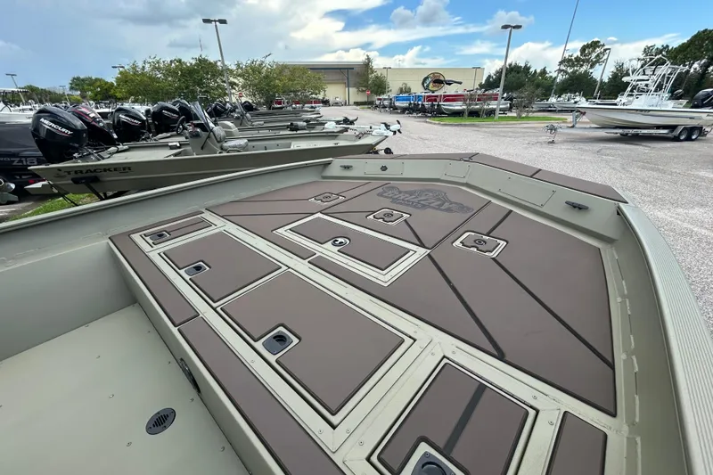 Slide: The Image of 2026 Tracker Grizzly 2072 CC boat with storage compartments, parked outdoors. - 6