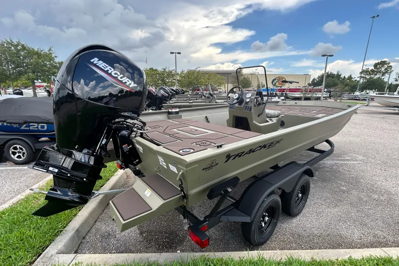 Slide: The Image of 2026 Tracker Grizzly 2072 CC boat with Mercury engine on a trailer in a parking lot. - 2